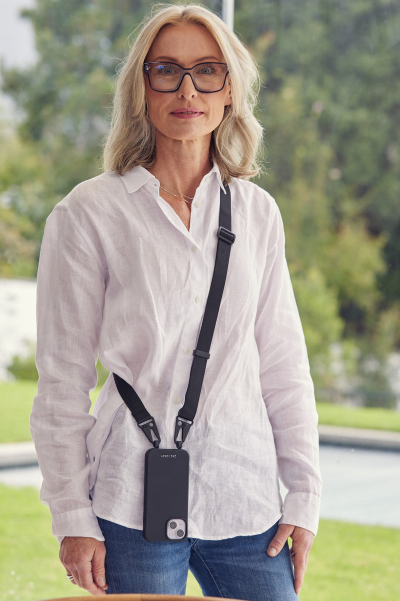 a woman wearing glasses and a camera strap