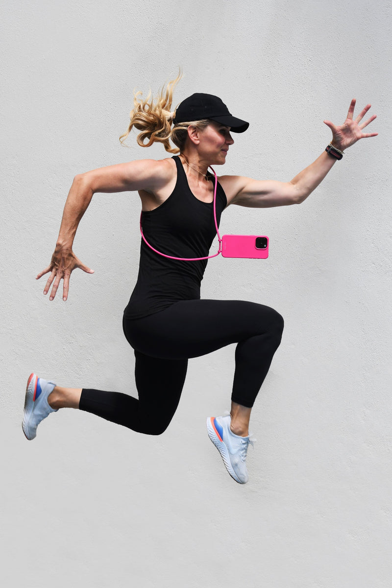 a woman is jumping in the air while wearing a hat