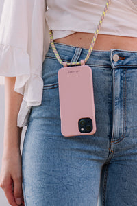 a woman holding a pink cell phone in her pocket